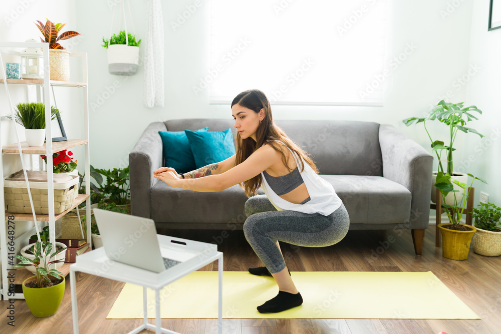 Side view of a good-looking woman exercising at home Side view of a good-looking woman exercising at home