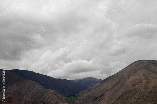 Inspirational natural background for quotes. Cloudscape. View of the arid mountain range peaks under a beautiful white and cloudy sky. 