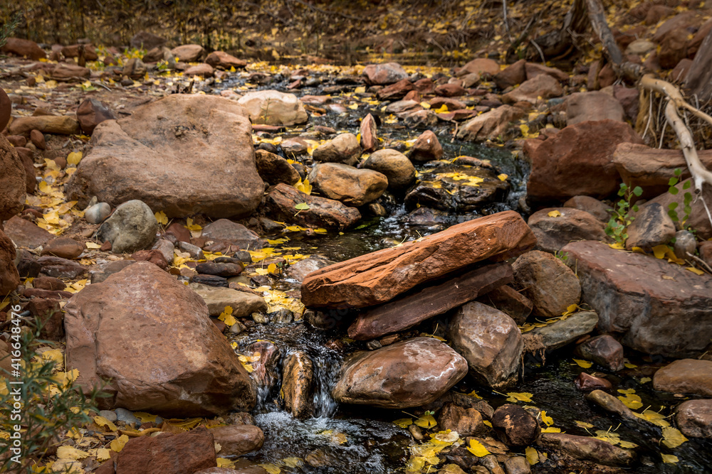 River Flowing Over Sandstone Boulders With Autumn Leaves River Flowing Over Sandstone Boulders With Autumn Leaves