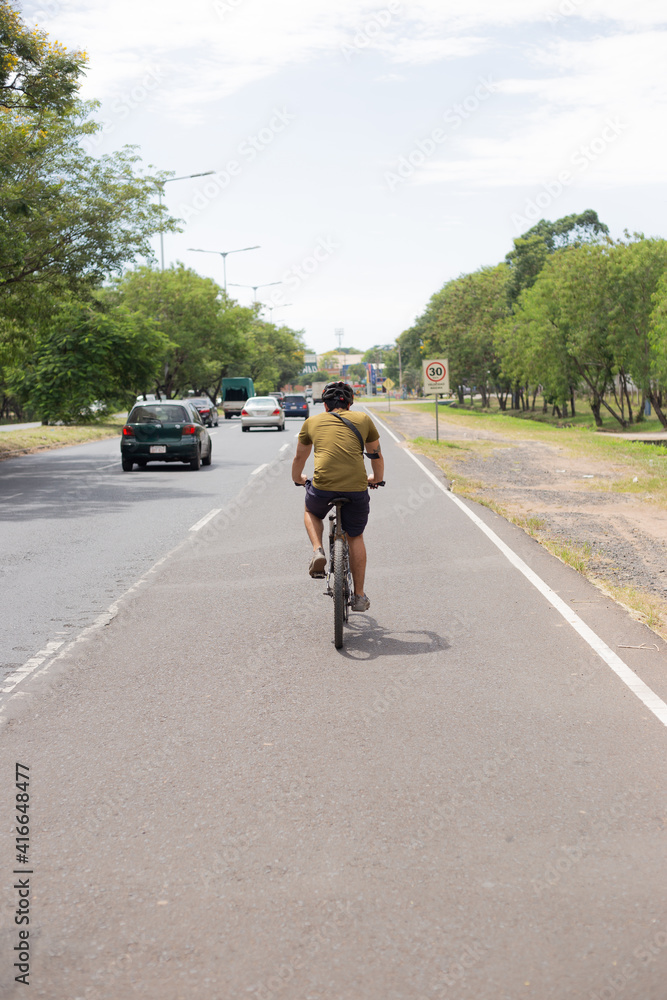Fototapeta premium Hombre joven pedalea por ñu guazu asunción al medio dia