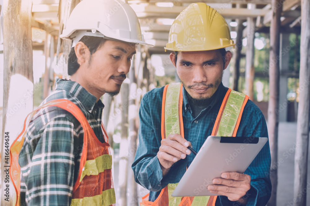 Two Engineer worker use tablet on site construction real estate project Two Engineer worker use tablet on site construction real estate project