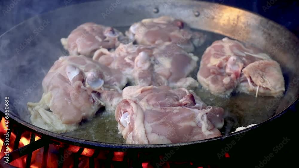 Raw chicken frying over fire Raw chicken frying over fire