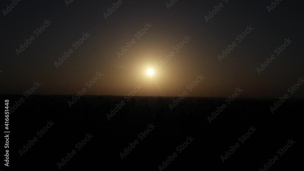 The sun rises over the horizon on a day darkened by fog, smog or haze The sun rises over the horizon on a day darkened by fog, smog or haze