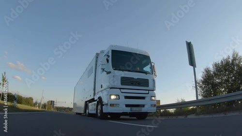 Wallpaper Mural Cargo truck with cargo trailer driving on a highway. White Truck delivers goods in early hours of the Morning - very low angle drive thru close up shot. Torontodigital.ca