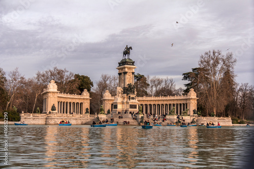 Madrid, Spain; March 7, 2019. Monument to Alfonso XII in front of the lake in the Retiro Park. Tourists on the lake strolling with their boats.