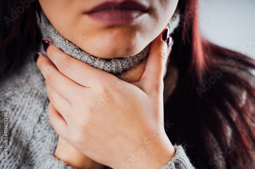 Papier peint Sore throat, a woman holding her hands to her throat, close-up