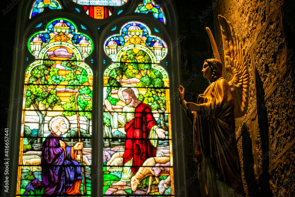 Obraz premium stained glass window in church with statue of an angel
