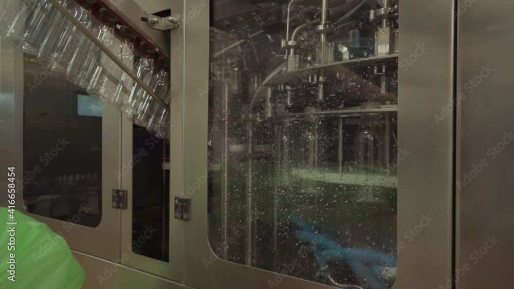 Dairy product packaging process. A factory worker is feeding empty