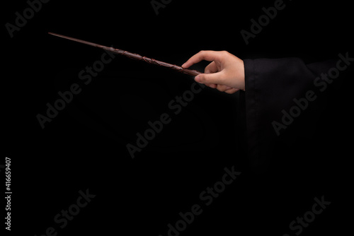 Fotografia Magic wand stick, Teens hand holding a wand wizard conjured up in the air