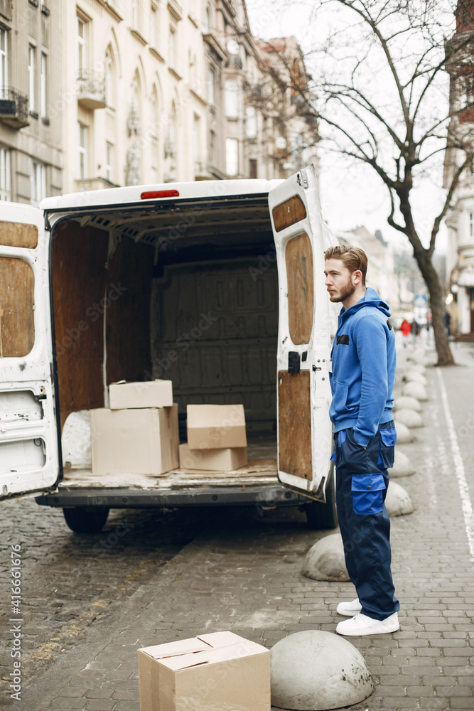 Naklejka premium Man by the truck. Guy in a delivery uniform.