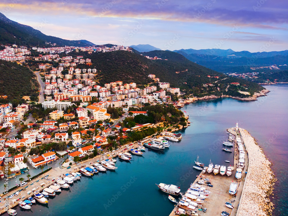 Scenic aerial view of small fishing, yachting and tourist town of Kas along shoreline of Aegean Sea at sunset, Turkey