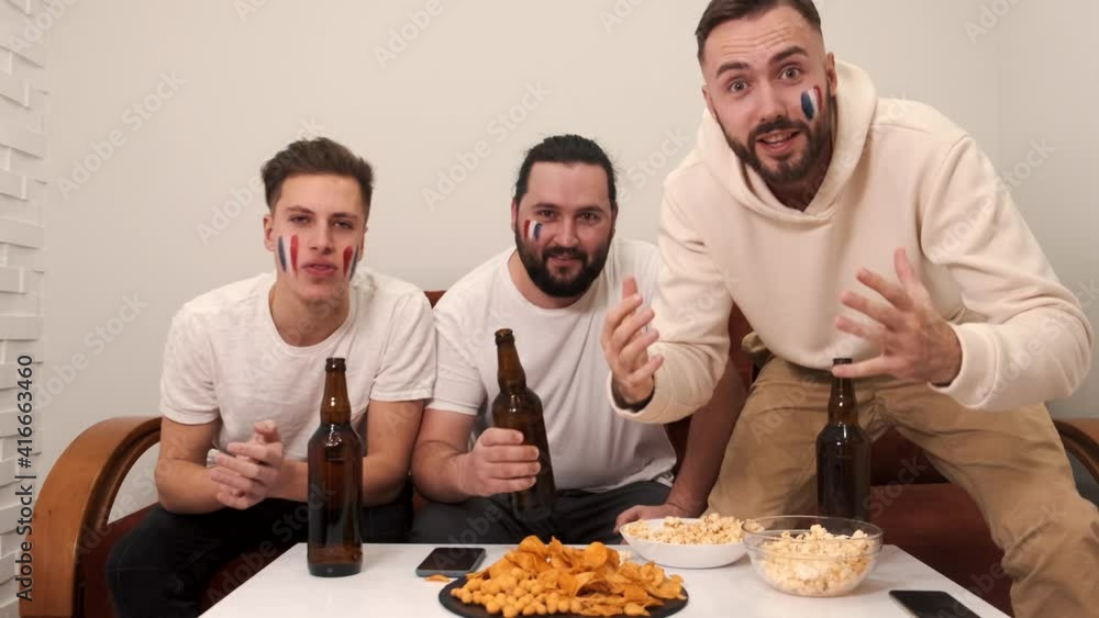 Friends watching sport on tv. Male friends watching sport on tv. Friends watching sport on tv. Male friends watching sport on tv.