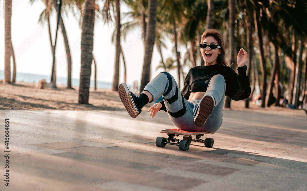 Close-up,Asian women surf skate or skates board outdoors on beautiful summer day. Happy young women play surf skate at beach on evening time.Skatebaord and long board concept. Close-up,Asian women surf skate or skates board outdoors on beautiful summer day. Happy young women play surf skate at beach on evening time.Skatebaord and long board concept.