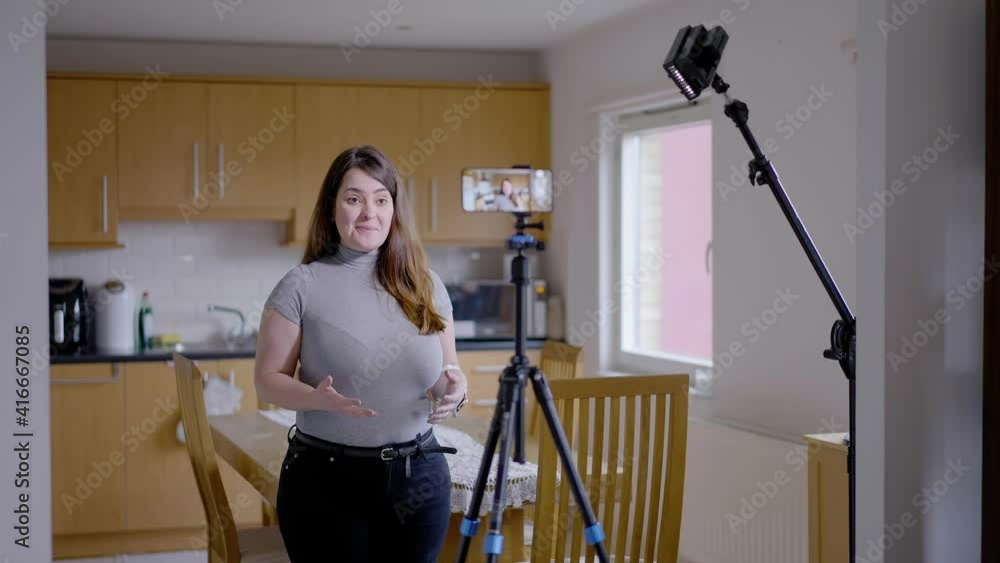 Overweight influencer recording video or e-learning with a kitchen as background Overweight influencer recording video or e-learning with a kitchen as background