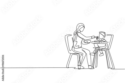 One single line drawing of young mother feeding her son a meal who sit at baby dining chair at home vector graphic illustration. Happy family parenting concept. Modern continuous line draw design