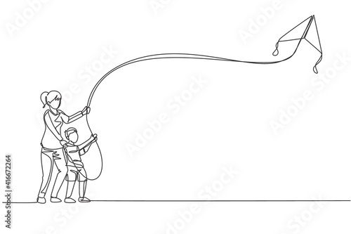 Single continuous line drawing of young mom and her son playing to fly kite up into the sky at outdoor field. Happy family parenthood concept. Trendy one line draw design vector graphic illustration