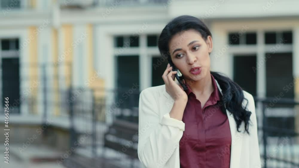 Calm businesswoman talking phone outdoors. Focused lady using smartphone Calm businesswoman talking phone outdoors. Focused lady using smartphone