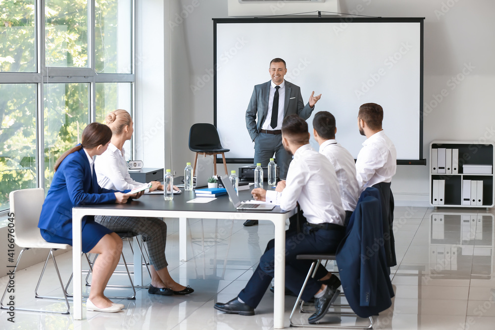 Obraz premium Mature businessman giving presentation during meeting in office