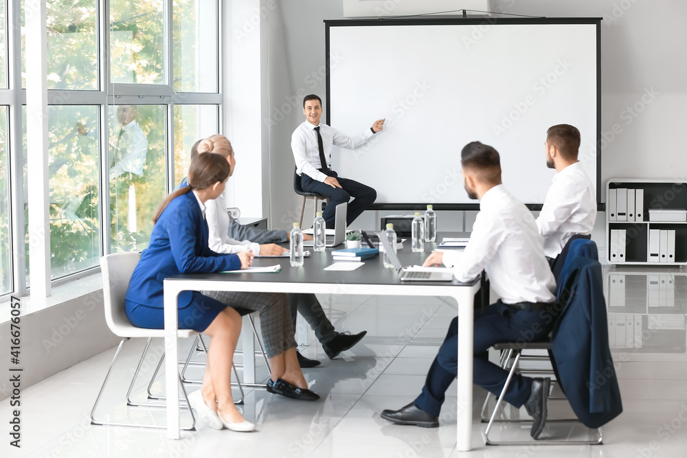 Businessman giving presentation during meeting in office