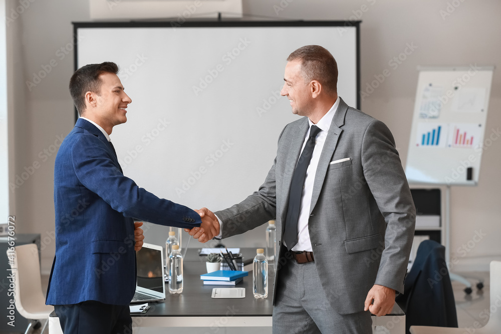 Businessmen shaking hands in office Businessmen shaking hands in office