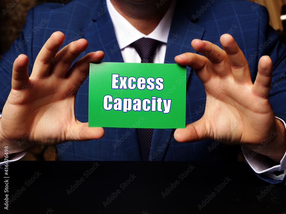 Young man holding a blank card in hands. Conceptual photo about Excess Capacity with written text. Young man holding a blank card in hands. Conceptual photo about Excess Capacity with written text.