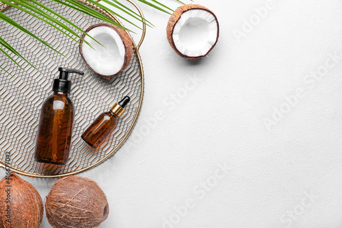 Composition with bottles of coconut oil on light background