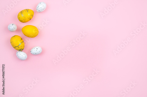 Happy easter concept. Eggs are yellow on a pink pastel background. Flat lay, top view, copy space.