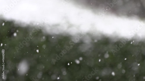 Falling snowflakes on blurred background.