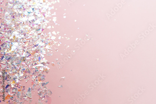 neon pearl foil confetti on light pink background. Festive, party or holiday glowing backdrop. Flat lay, top view. © IKvyatkovskaya