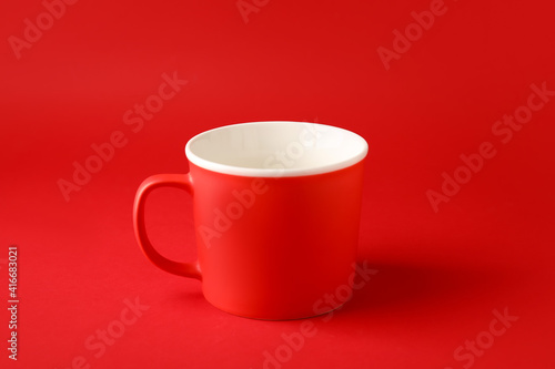 Empty cup on color background