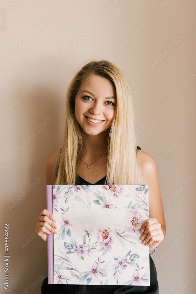 The girl holds in her hands beautiful photo albums or photo books in the spring style The girl holds in her hands beautiful photo albums or photo books in the spring style