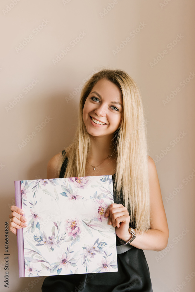 The girl holds in her hands beautiful photo albums or photo books in the spring style The girl holds in her hands beautiful photo albums or photo books in the spring style