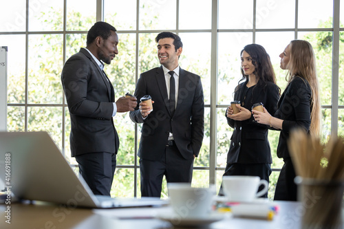 Employees are chatting happily during coffee break. Multicultural management teams have fun talking about work. photo