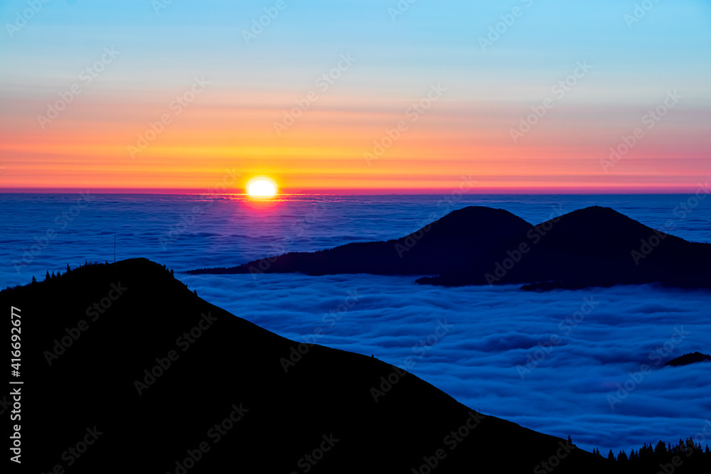 Sunrise with sea of clouds in horizon	