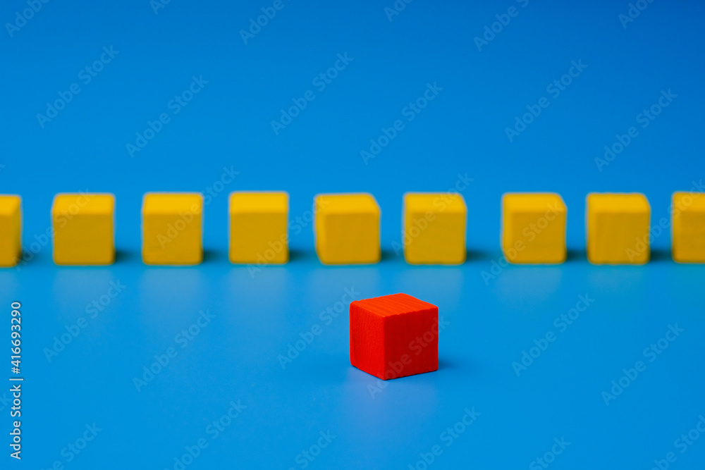 Red wooden block standing out on blue background. Abstract leadership concept Red wooden block standing out on blue background. Abstract leadership concept