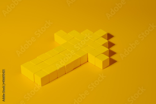 Arrow made with yellow wooden blocks, closeup. Abstract business and leadership concept