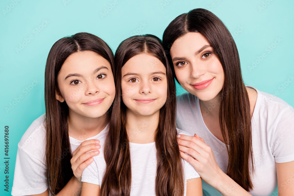 Photo of adorable cute three sisters dressed white outfit smiling cuddling isolated turquoise color background Photo of adorable cute three sisters dressed white outfit smiling cuddling isolated turquoise color background