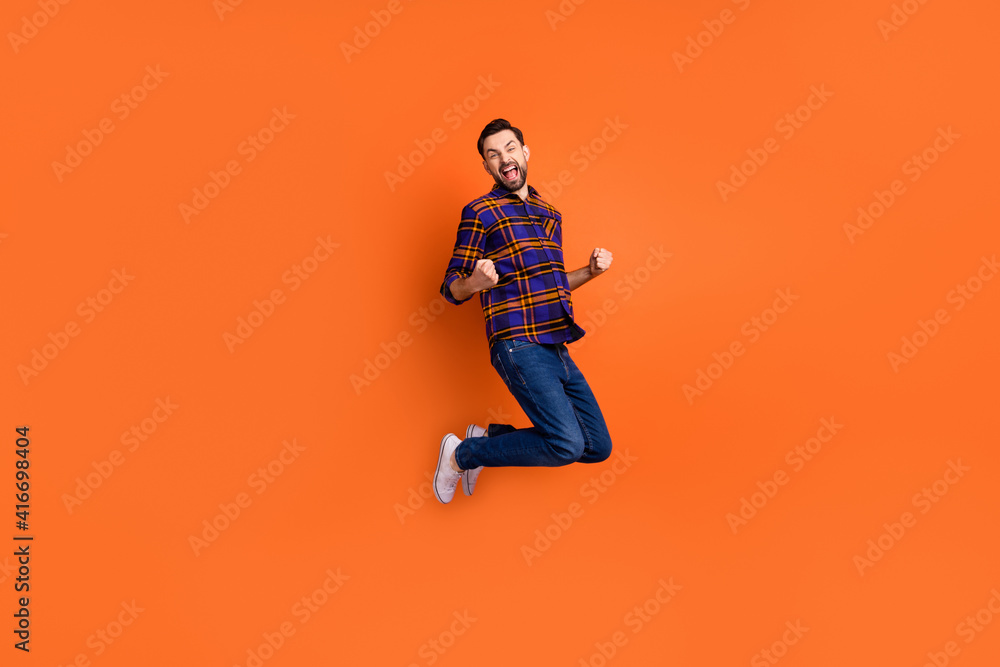 Full body photo of astonished person fists up open mouth shout yes isolated on orange color background Full body photo of astonished person fists up open mouth shout yes isolated on orange color background