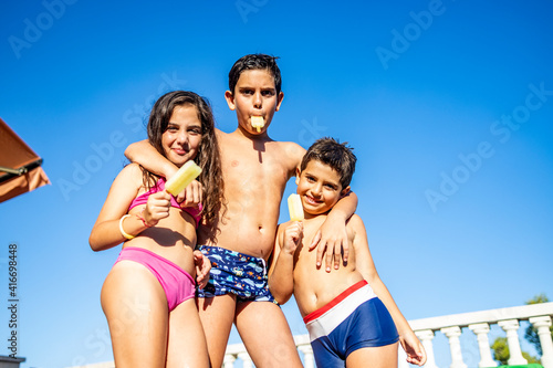Three funny kids eating an ice lolly © Victor