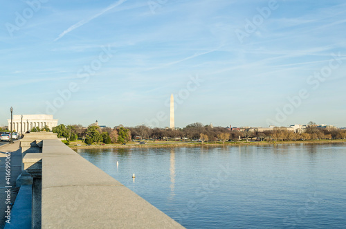 Potomac River Calm Waters and Washington Monument Obelisk in Background. Arlington Bridge Leads to Lincoln Memorial. Washington DC, USA. Sunny Day with Blue Sky