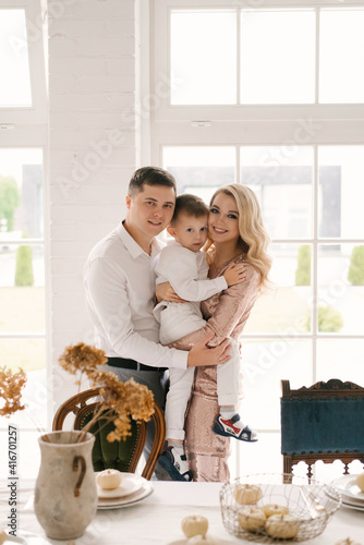 Beautiful young family man woman and son in smart clothes in a luxurious bright interior, happy family