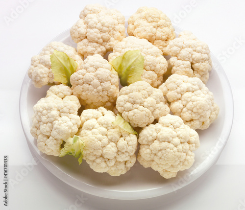 Coliflor  cruda sobre fondo blanco, vista cenital. Raw cauliflower on white background, overhead view.