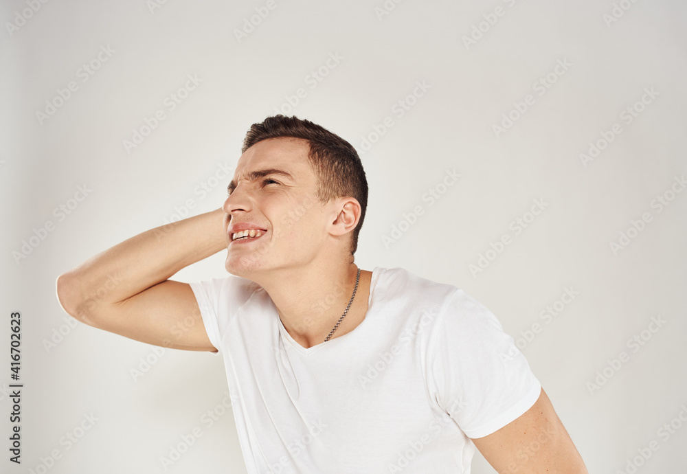 Portrait of a pensive man in a white T-shirt side view light background Portrait of a pensive man in a white T-shirt side view light background