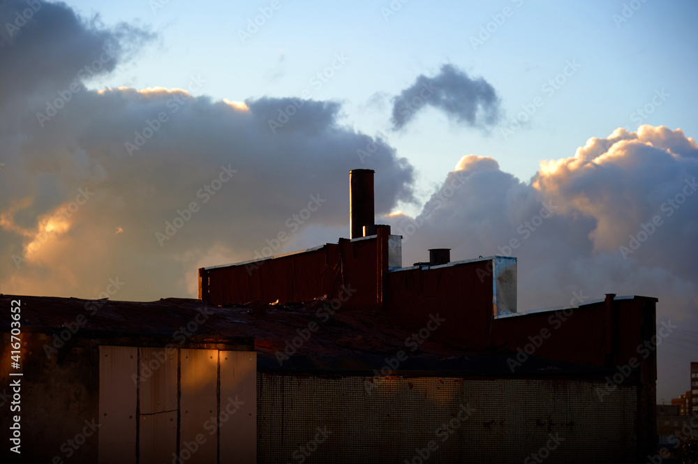 The roof of the old factory against the background of the sky and sunset.
