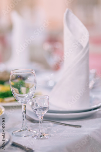 The restaurant has pink wedding tables, banquet, serving plates, glasses, fork and knife.