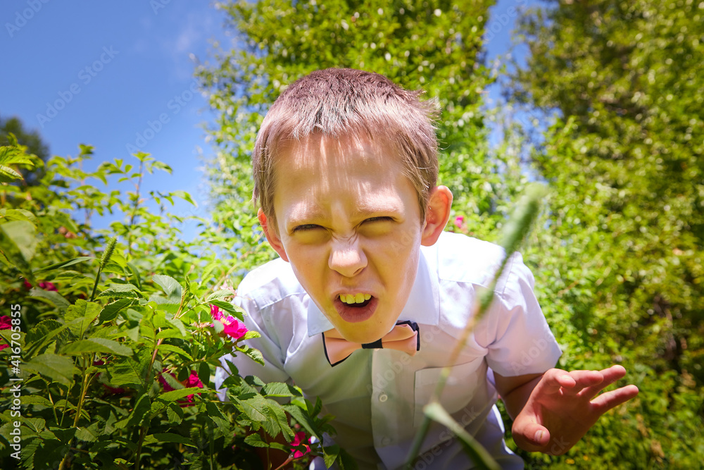 A boy in a white shirt and a pink butterfly in nature among the greenery A boy in a white shirt and a pink butterfly in nature among the greenery