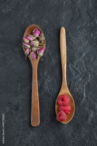 Budding roses and raspberries on wooden spoons