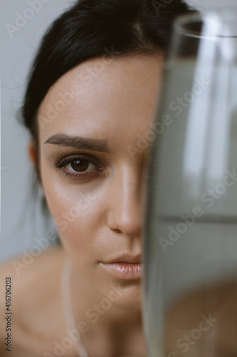 Free Download Beautiful brunette girl looking at the camera through a vase of water. Portrait - GFXLoad