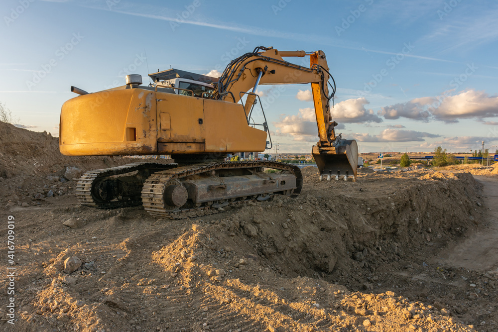 Excavator moving dirt and sand at a construction site Excavator moving dirt and sand at a construction site