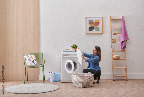 Laundry room washing machine and dirty clothes decorative modern style. Woman is taking or put clothes from the machine.